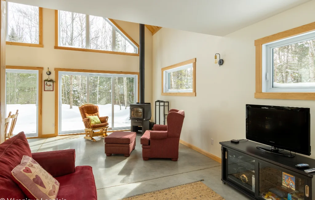Salon avec poêle à bois et vue sur la neige