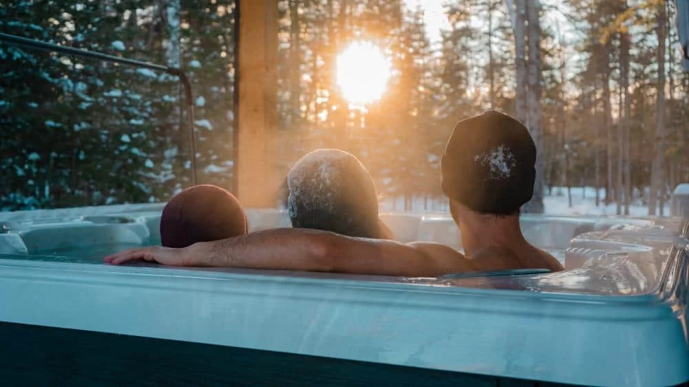 Détente dans le spa au coucher du soleil en hiver