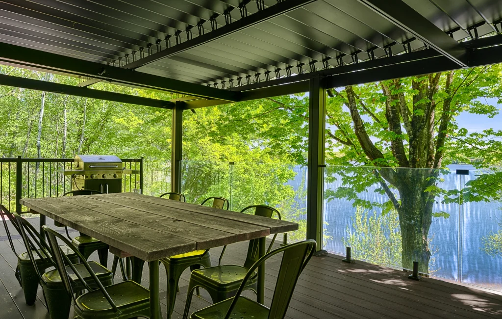 Salle à manger extérieure sous la pergola, face au lac