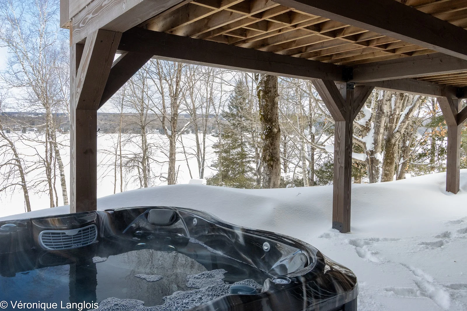 Spa extérieur couvert avec vue sur le lac gelé