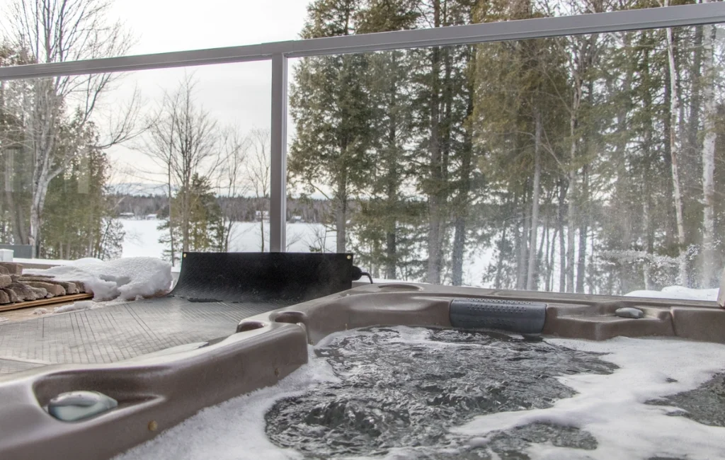 Spa extérieur en hiver avec vue sur le lac gelé