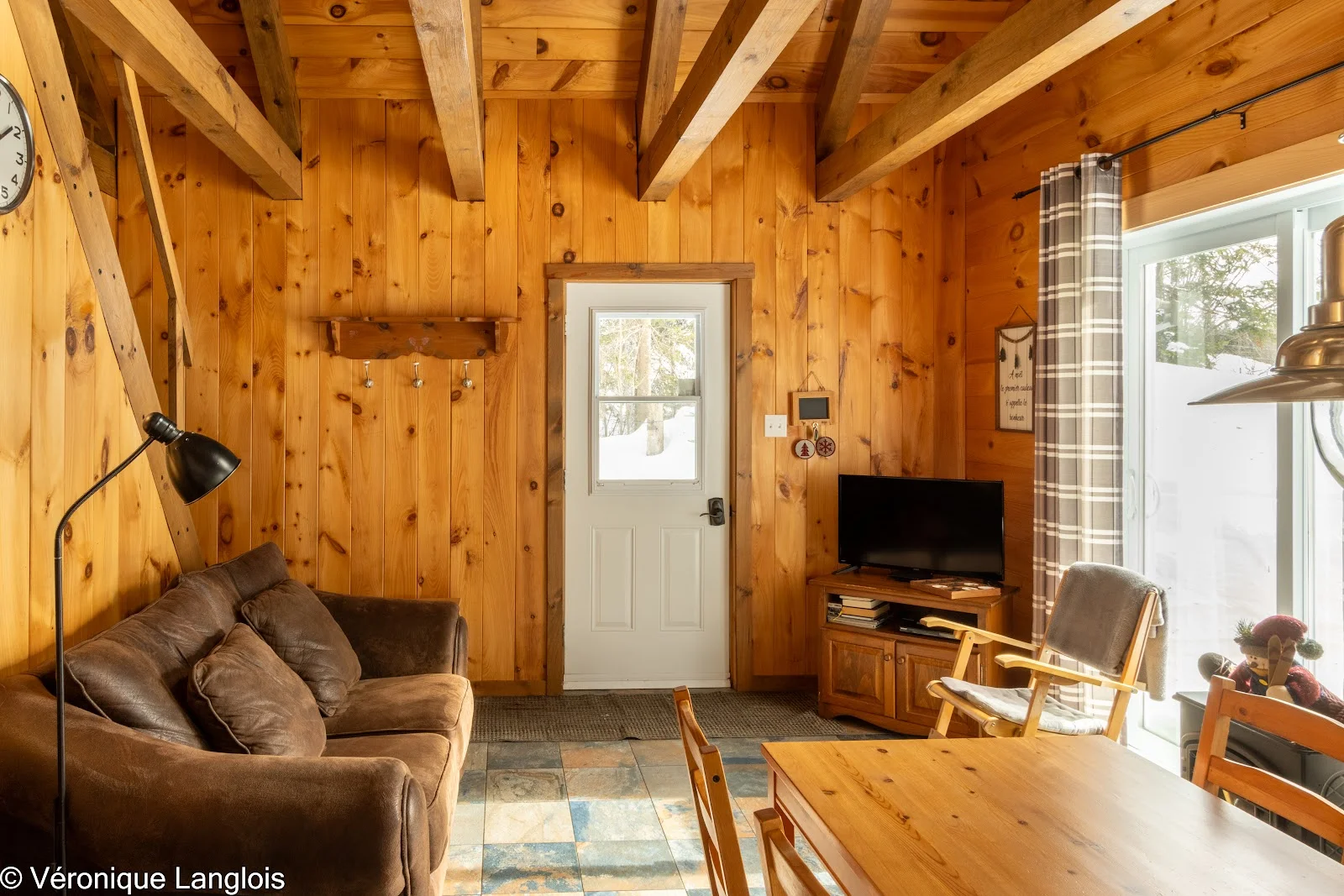 Salon tout en bois avec canapé et lumière d'hiver