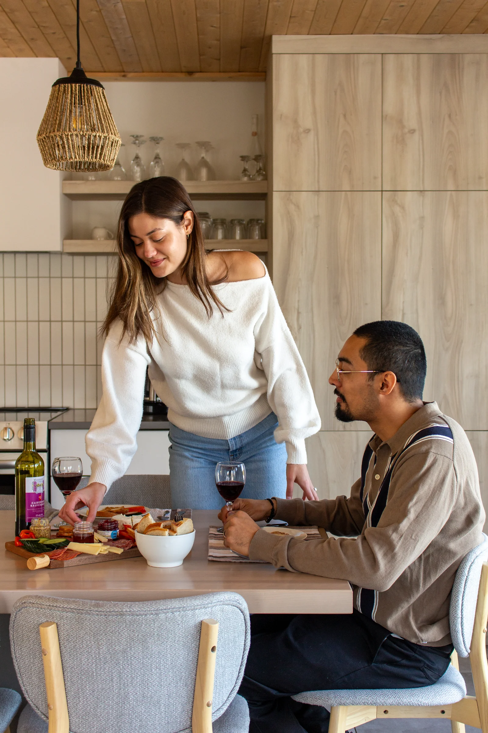 Couple autour de l'îlot de cuisine avec vin et bouchées